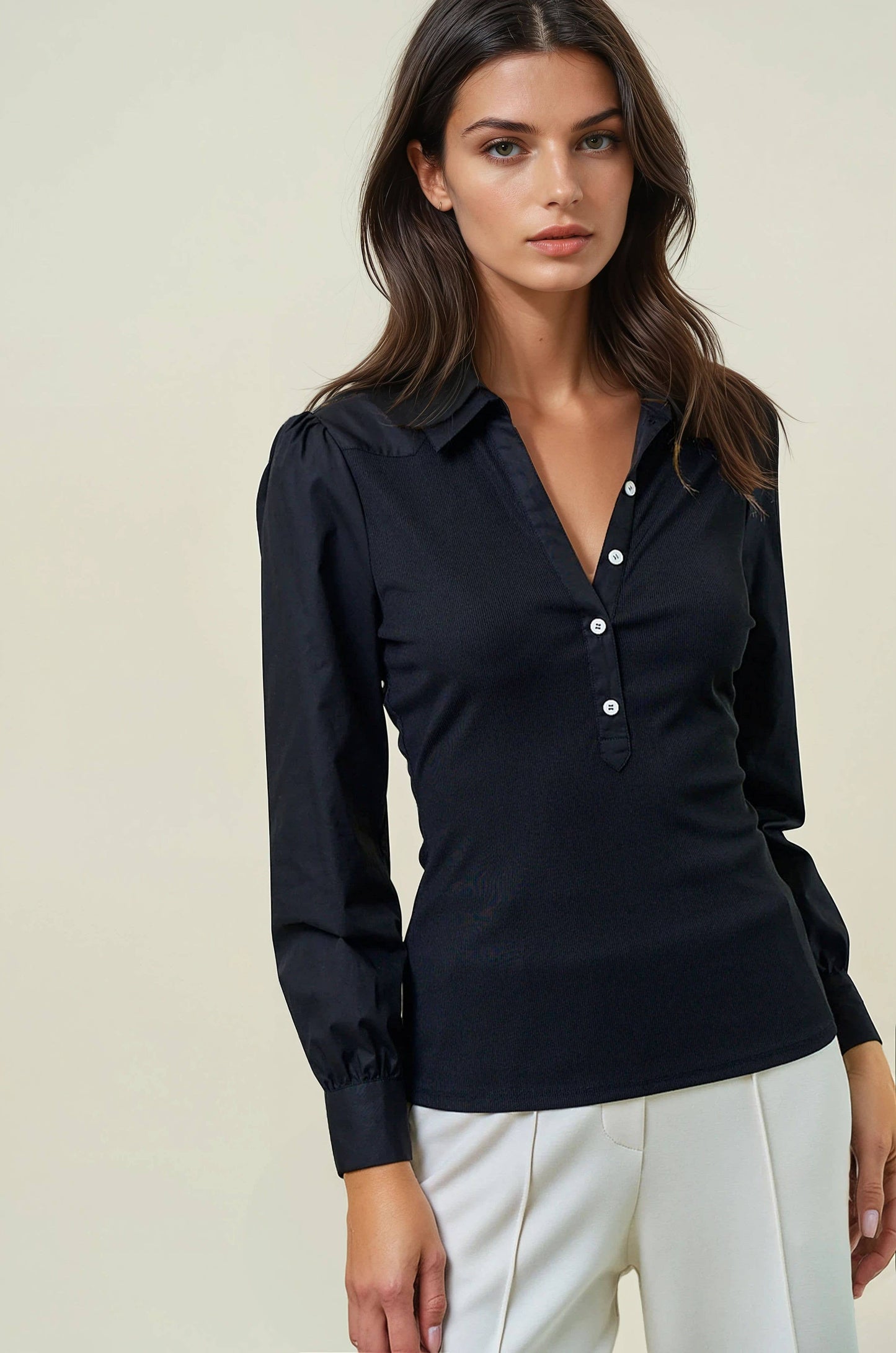 Woman wearing a black blouse with a plain background