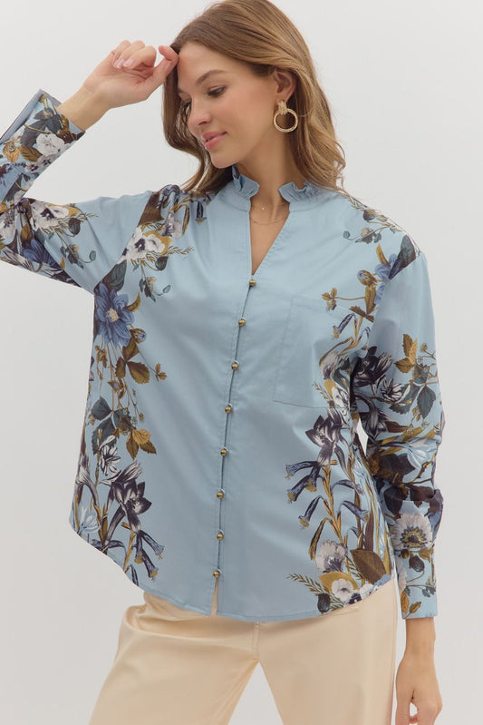 Woman wearing a light blue floral blouse against a white background
