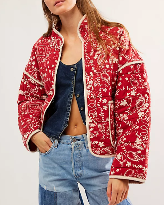 Person wearing a red floral-patterned jacket over a denim outfit on a white background