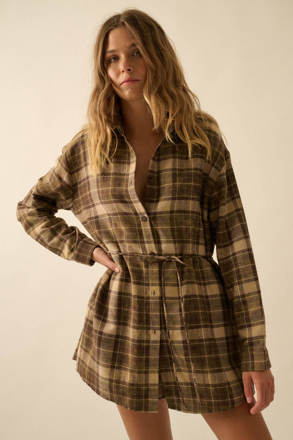 Woman wearing a plaid dress against a plain background