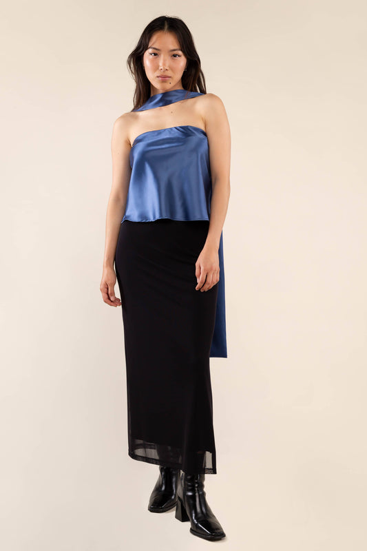 Woman wearing a blue and black dress against a plain background