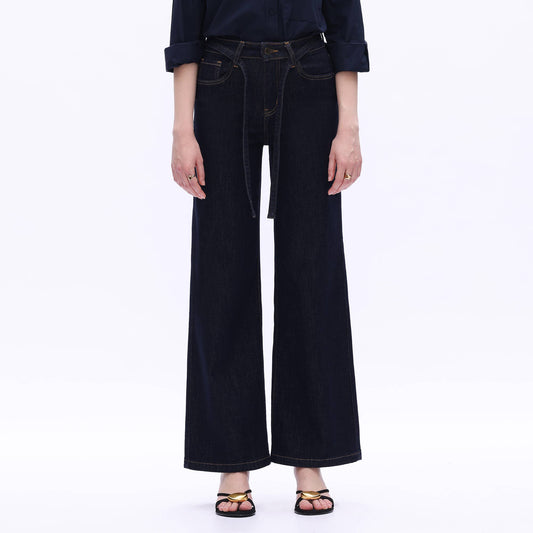 Person wearing black wide-leg jeans on a white background