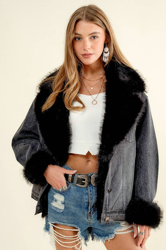 Woman wearing a denim jacket with black fur trim, white top, and ripped jeans on a beige background