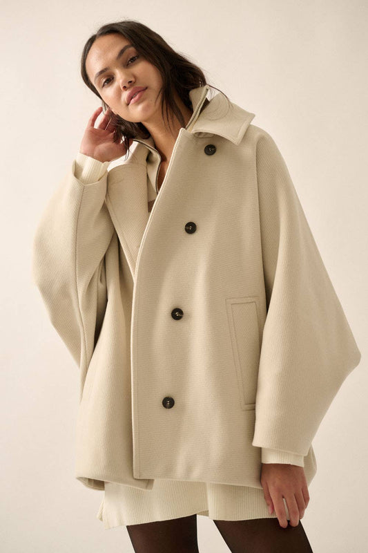 Woman wearing a beige coat with a plain background
