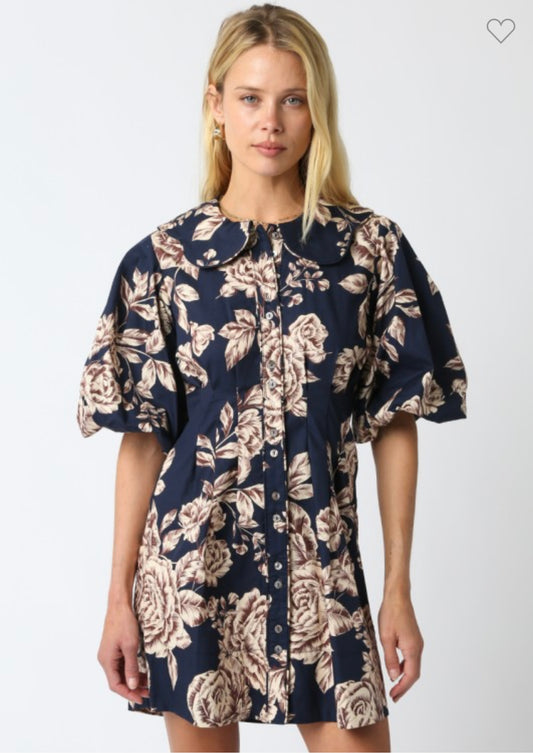 Woman wearing a navy floral dress on a white background