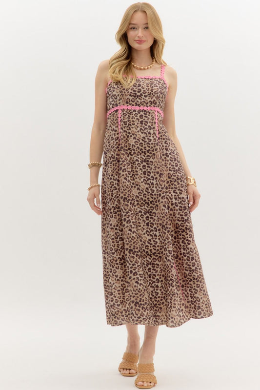 Woman wearing a leopard print dress with pink accents on a white background