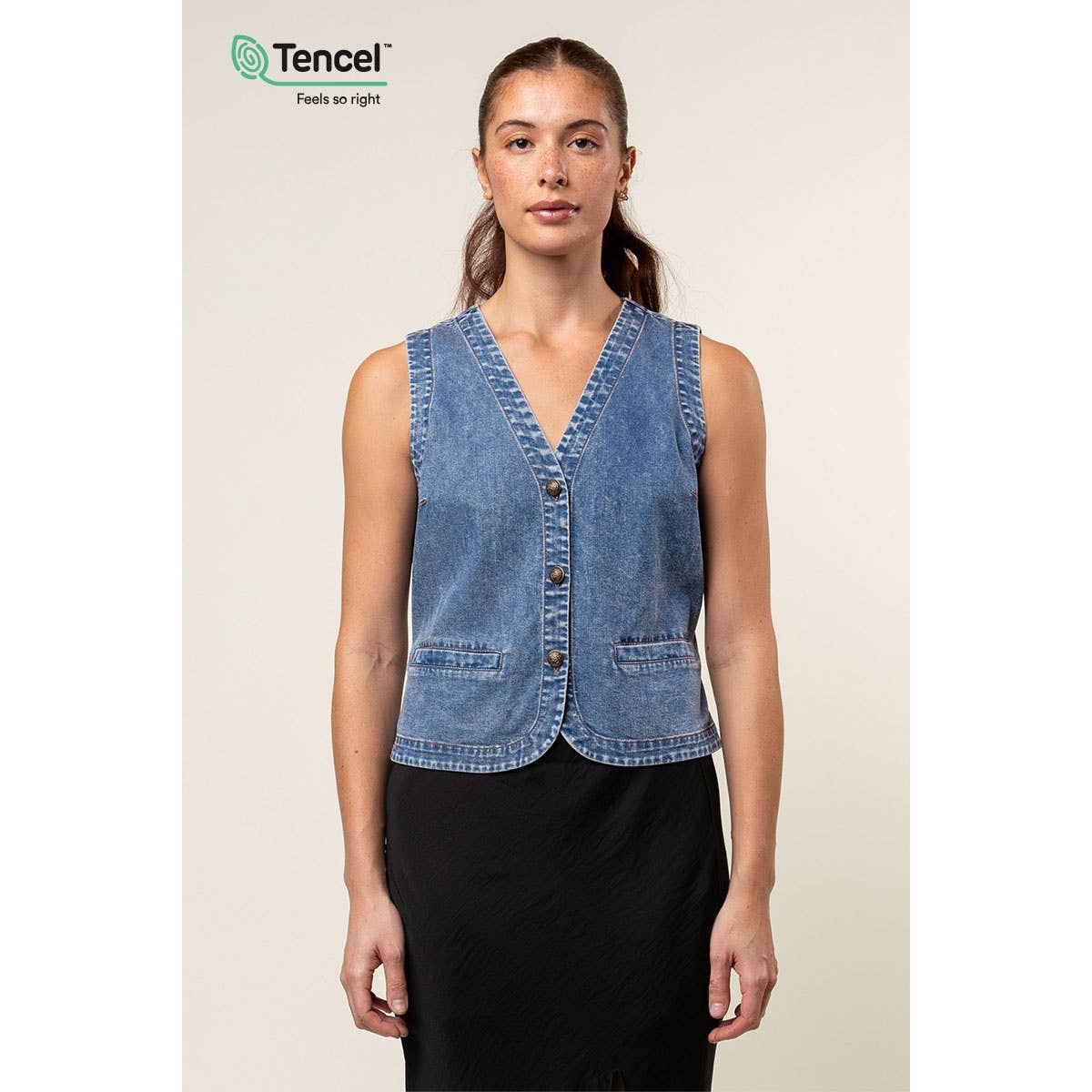 Woman wearing a denim vest with Tencel logo in the corner