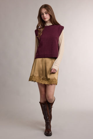 Tan satin mini skirt with lace trim hem, styled with burgundy sweater vest