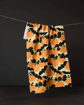 Halloween tea towel with orange pumpkins and black bats pattern hung on twine