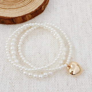 Triple-strand white pearl bead stretch bracelet set with gold puffed heart charm