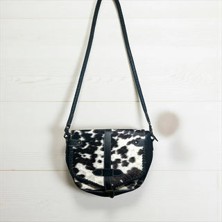 Black and white cowhide leather crossbody bag with braided strap and flap closure