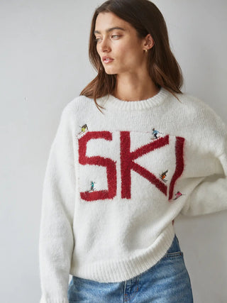 White knit ski sweater with red SKI lettering and small skier figures