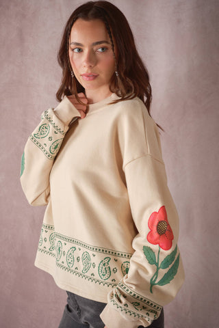 Cream oversized sweatshirt with green paisley print and red floral sleeve graphic