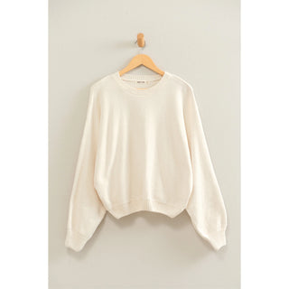 Cream chenille crew neck sweater with balloon sleeves and ribbed cuffs on wooden hanger