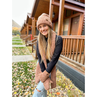 Mixed tone tan boucle knit cuff beanie hat worn by smiling woman outdoors