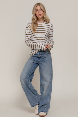 White and olive striped long sleeve round neck tee paired with wide-leg jeans