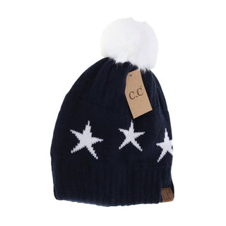Navy blue knit beanie with white star pattern and white faux fur pom pom