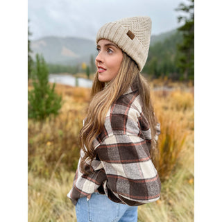 Beige crisscross knit C.C beanie with brown leather logo patch, worn outdoors