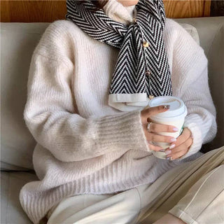 Cream oversized knit sweater with ribbed cuffs, paired with black and white chevron scarf