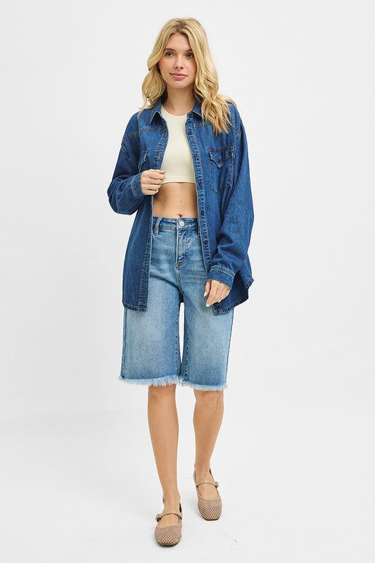 Woman wearing a denim jacket and shorts on a white background