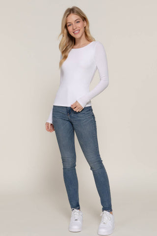 White long sleeve double layer round neck fitted tee worn with blue skinny jeans