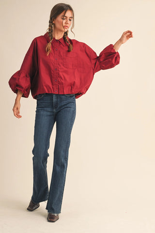 Burgundy cropped button-down shirt with puff sleeves and bubble hem on model