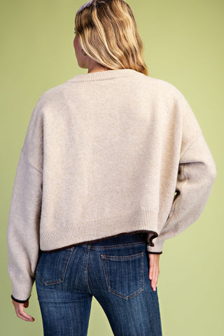 Taupe cropped knit sweater with dark contrast rolled hem and wide sleeves, back view