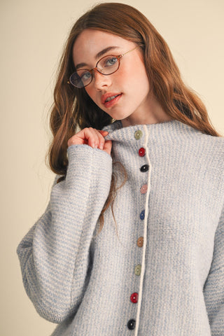 Powder blue knit cardigan with multicolored buttons and cream trim detail