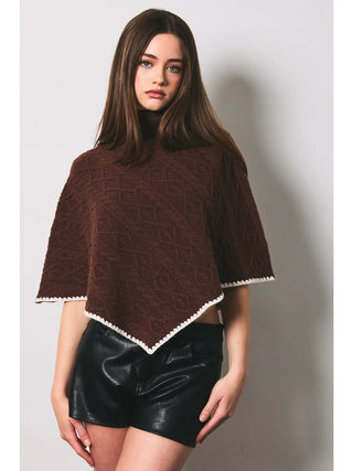 Brown cable knit sweater poncho with cream scallop trim and V-hem front