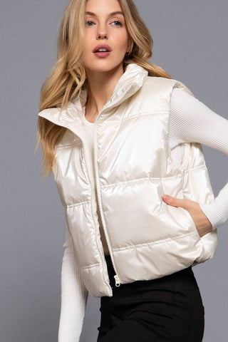 Women's ivory shiny puffer vest with high neck and zip front closure