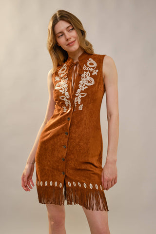 Brown suede sleeveless mini dress with white floral embroidery, fringe hem, and button front