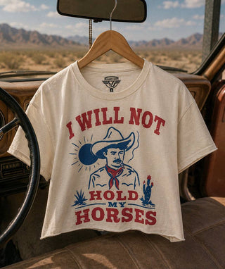 Cream cropped tee with red and blue cowboy graphic reading I Will Not Hold My Horses