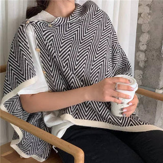 Black and white chevron knit poncho with cream trim and gold button details