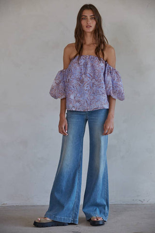 Lavender floral off-shoulder short sleeve top paired with wide-leg blue jeans