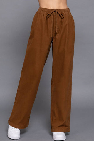 Brown elastic waist corduroy wide-leg pants with drawstring tie, worn with white sneakers