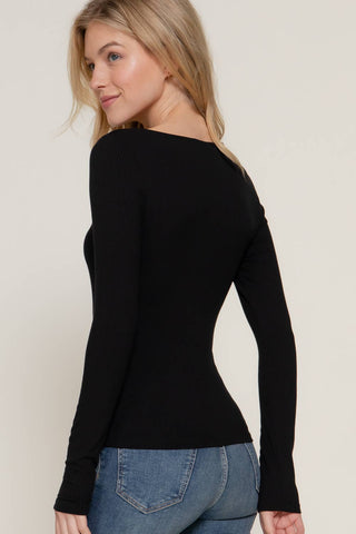 Black ribbed long sleeve round neck fitted tee worn with blue jeans, back view