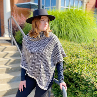 Black and white chevron knit poncho with turtleneck and cream trim border