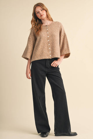 Tan knit cardigan with white buttons and elbow-length wide sleeves