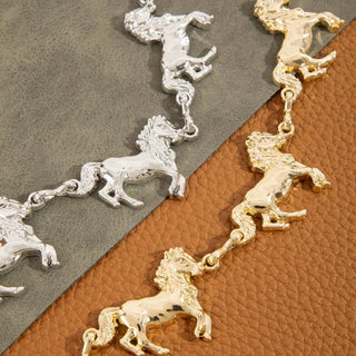 Silver and gold tone multi horse chain belt on leather and suede backdrop