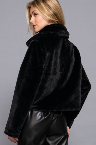Black faux fur cropped jacket with collar, long sleeves, paired with black leather pants