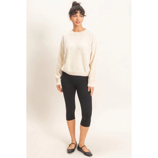 Cream chenille crew neck sweater styled with black capri leggings and flats