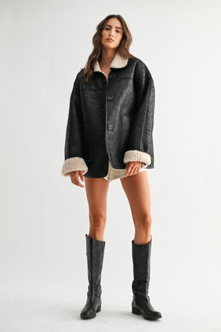Black reversible sherpa-lined leather jacket with cream cuffs and collar