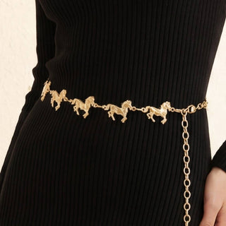 Gold chain belt with horse charms worn over black ribbed knit dress