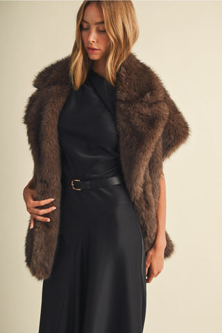 Cappuccino brown faux fur vest with wide lapels worn over black outfit