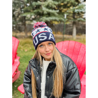 Navy blue USA knit pom beanie with red white stars pattern worn outdoors