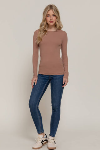 Women's fitted mauve long sleeve crew neck cotton jersey top with blue skinny jeans