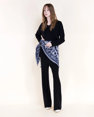 Navy blue paisley print triangular scarf with fringe edges tied at waist