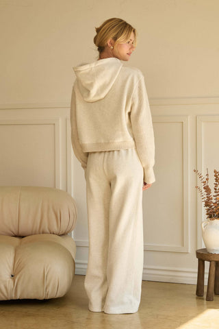 Wide-leg oatmeal knit pants with elastic waistband, styled with matching hoodie