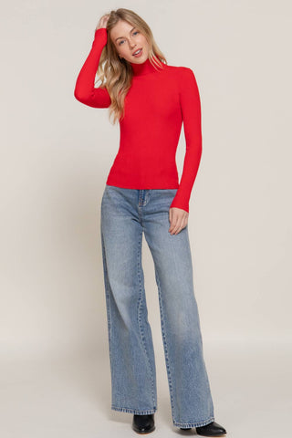 Red ribbed turtleneck long sleeve fitted sweater paired with wide-leg jeans
