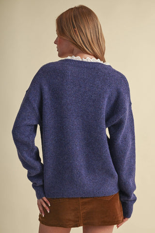 Navy blue knit sweater with white eyelet lace ruffle collar, back view